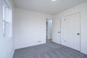 Unfurnished bedroom with carpet floors and baseboards