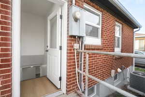 View of property exterior featuring brick siding and a cooling unit