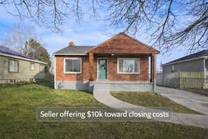 Bungalow featuring a chimney, brick siding, and a porch