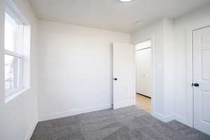 Unfurnished bedroom featuring carpet flooring and baseboards