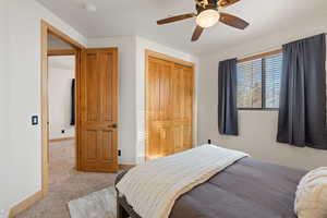 Carpeted bedroom featuring a closet and a ceiling fan