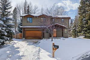 View of front facade with a garage and stucco siding