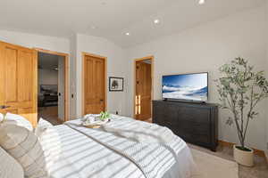 Primary Bedroom with light carpet, lofted ceiling, recessed lighting, and a closet