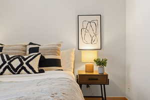 Bedroom featuring baseboards and wood finished floors and ensuite bathroom