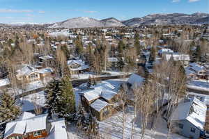 Snowy aerial view featuring a mountain view and a residential view