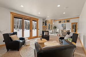 Carpeted living room with recessed lighting and baseboards