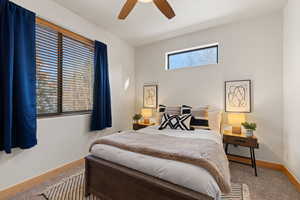 Carpeted bedroom with baseboards and a ceiling fan