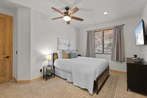 Bedroom with a ceiling fan, light carpet, and recessed lighting