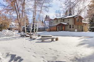 Snow covered front of property featuring a firepit in the cul-de-sac