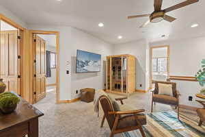 Loft area room featuring a light colored carpet, recessed lighting, ceiling fan, and plenty of natural light