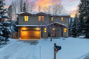 View of front of house with stucco siding and an attached garage