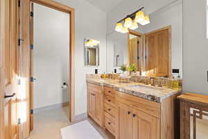Primary Bathroom featuring double vanity and baseboards