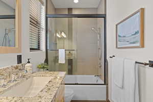 Full bath with bath / shower combo with glass door and vanity
