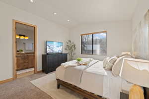 Primary Bedroom with light carpet, lofted ceiling, ensuite bathroom, and recessed lighting