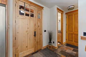 Foyer with stone tile floors and baseboards