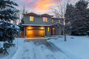View of front of house with an attached garage and stucco siding