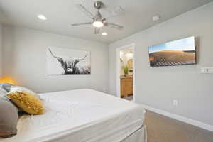 Bedroom featuring light colored carpet, a ceiling fan, ensuite bath, and recessed lighting