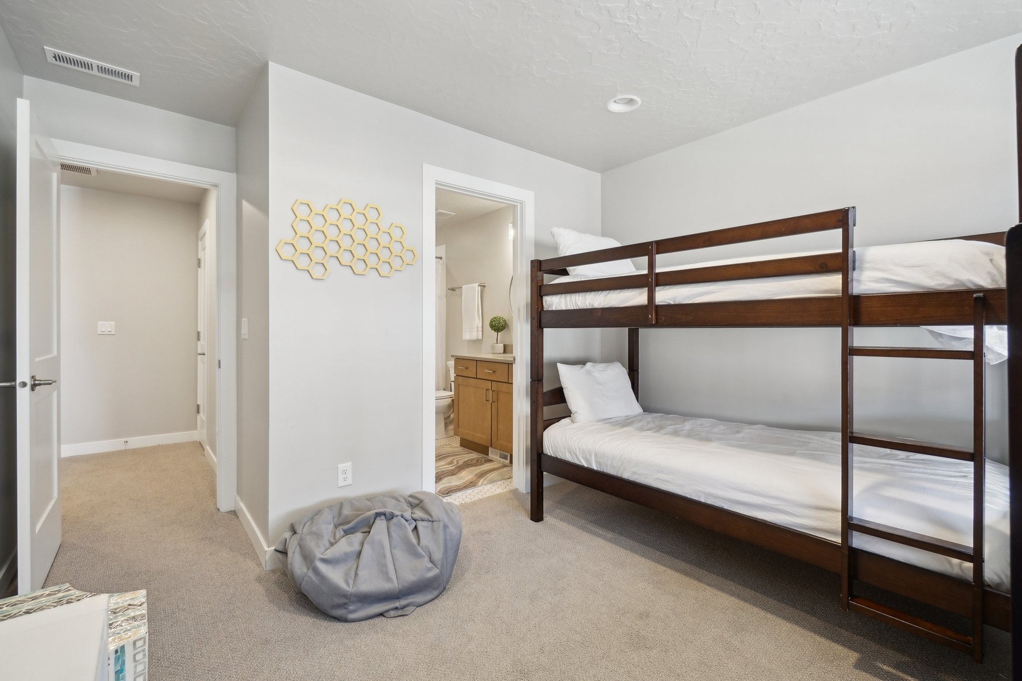 Bedroom with light carpet, connected bathroom, and a textured ceiling