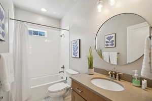 Bathroom with shower / bath combo with shower curtain and vanity