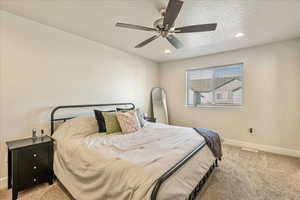 Bedroom featuring light carpet, a textured ceiling, ceiling fan, and recessed lighting