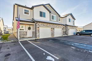 View of front of house with stone siding, board and batten siding, a residential view, and an attached garage