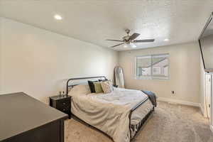Bedroom featuring recessed lighting, a textured ceiling, ceiling fan, and light colored carpet