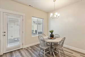 Dining area featuring light wood-type flooring and a chandelier