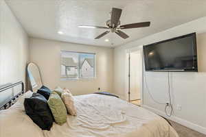 Bedroom with ceiling fan, a textured ceiling, recessed lighting, and light carpet