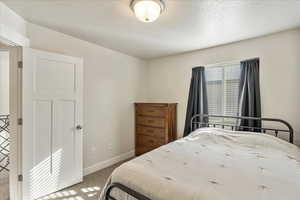 Bedroom with carpet and a textured ceiling