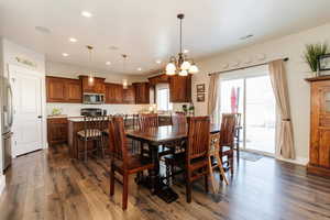 Dining area featuring dark wood finished floors, a chandelier, and recessed lighting