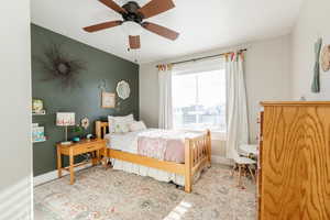 Bedroom featuring an accent wall and a ceiling fan