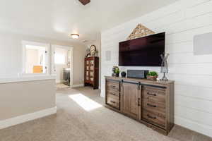 Living room with light carpet and wooden walls