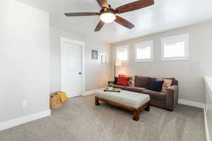 Living room with light colored carpet and ceiling fan