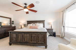 Bedroom with light carpet, ceiling fan, and wallpapered walls