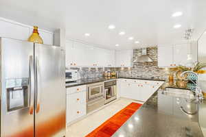 Kitchen featuring stainless steel appliances, hanging light fixtures, recessed lighting, white cabinetry, and light tile patterned flooring