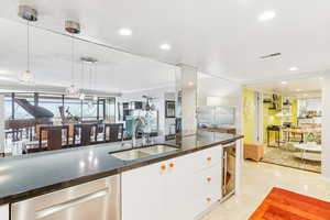 Kitchen featuring white cabinetry, dishwasher, hanging light fixtures, wine cooler, and modern cabinets