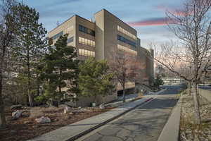 Property at dusk featuring a view of apartment building / complex