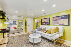 Living area featuring recessed lighting, ornamental molding, and light wood-style flooring