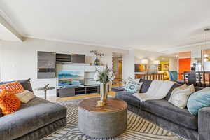 Living area with crown molding and wood finished floors