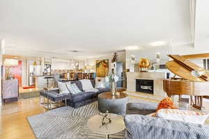 Living room featuring a fireplace, wood finished floors, and crown molding