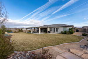 Rear view of property featuring a patio area, stucco siding, and a fenced backyard