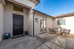 Doorway to property with stucco siding and a patio area