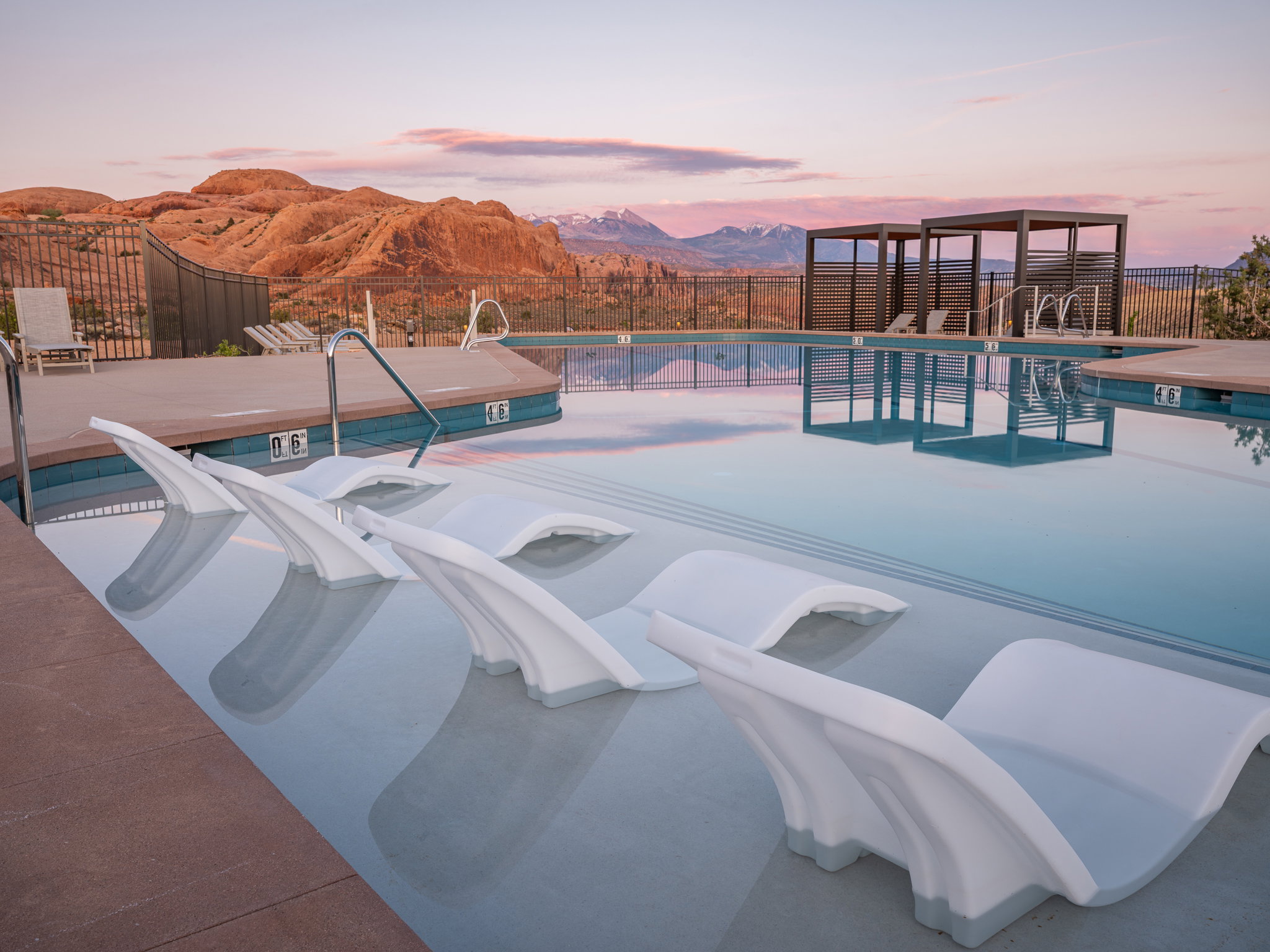 Resort-style pool featuring integrated in-water loungers and a Baja shelf