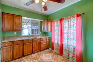 Kitchen with brown cabinetry, light countertops, and light tile patterned flooring