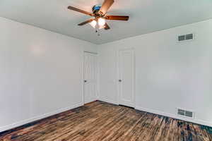 Spare room featuring dark wood-style floors and ceiling fan