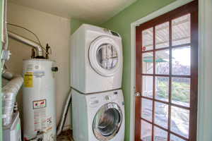 Laundry area with gas water heater and estacked washer and dryer