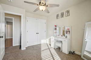 Bedroom featuring light carpet, a ceiling fan, and a closet