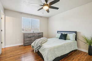 Bedroom featuring hardwood / wood-style floors, a textured ceiling, and ceiling fan