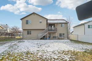 Snow covered property with a fenced backyard, a patio, and stairs