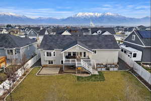 Back of house featuring a fenced backyard, a deck with mountain view, and a residential view